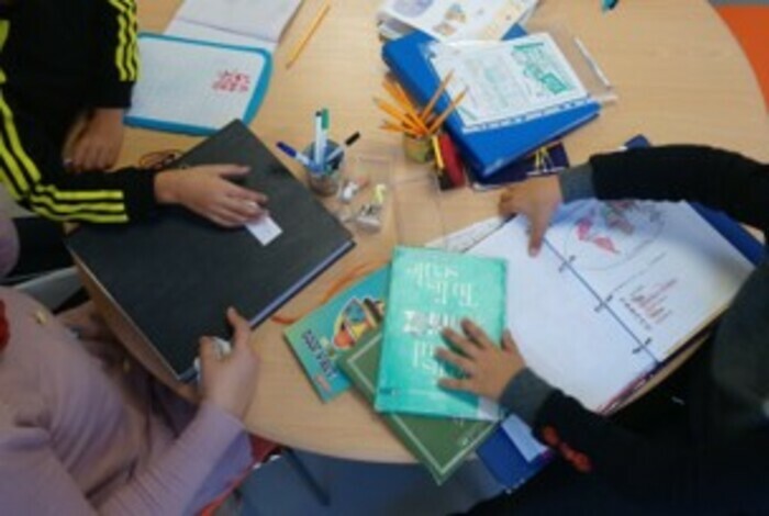 Accueil en petits groupes de parents avec leurs enfants, pour faire les devoirs ensemble.